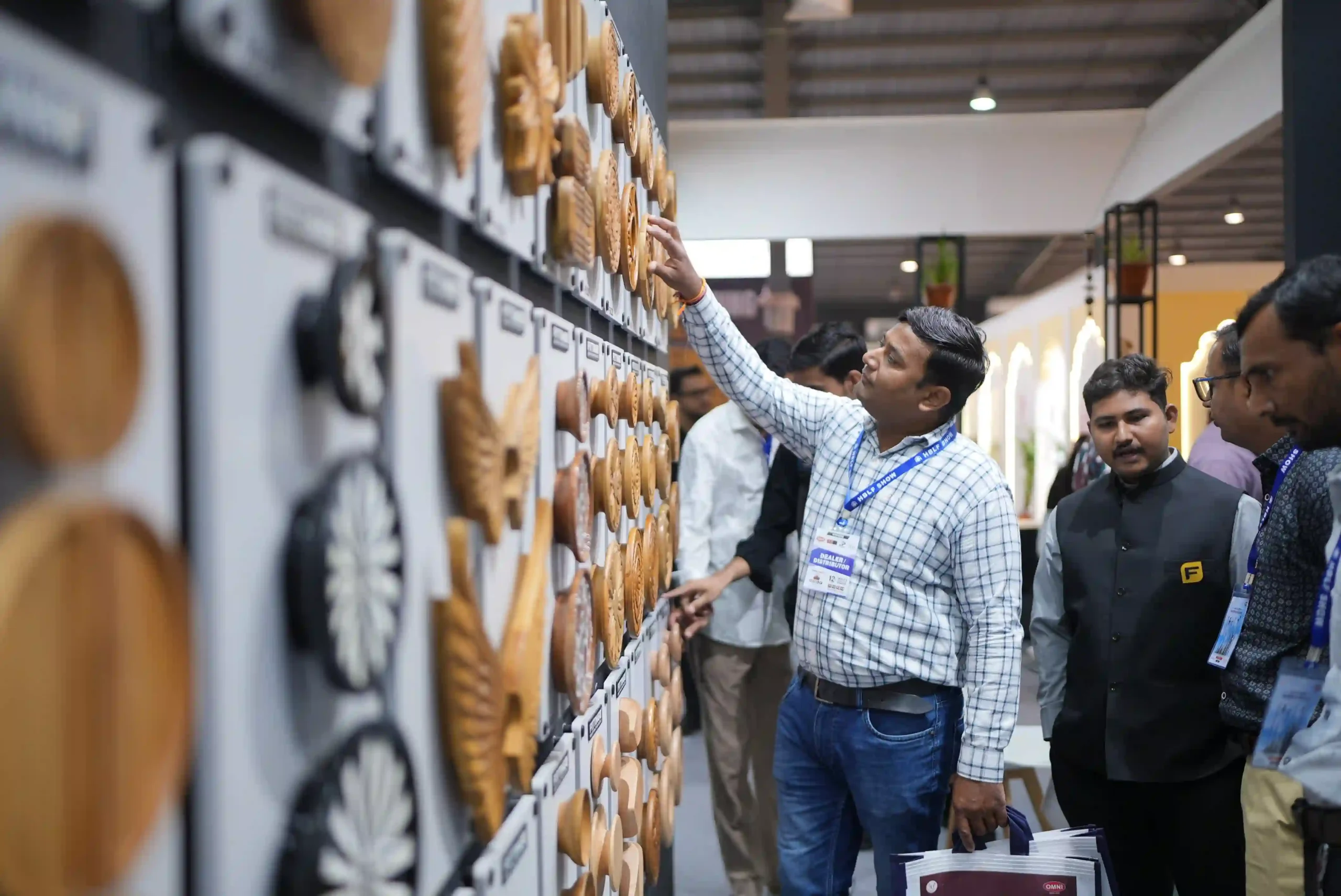 A dealer reaching up to touch a carved wooden rosette while Fittingo staff look on