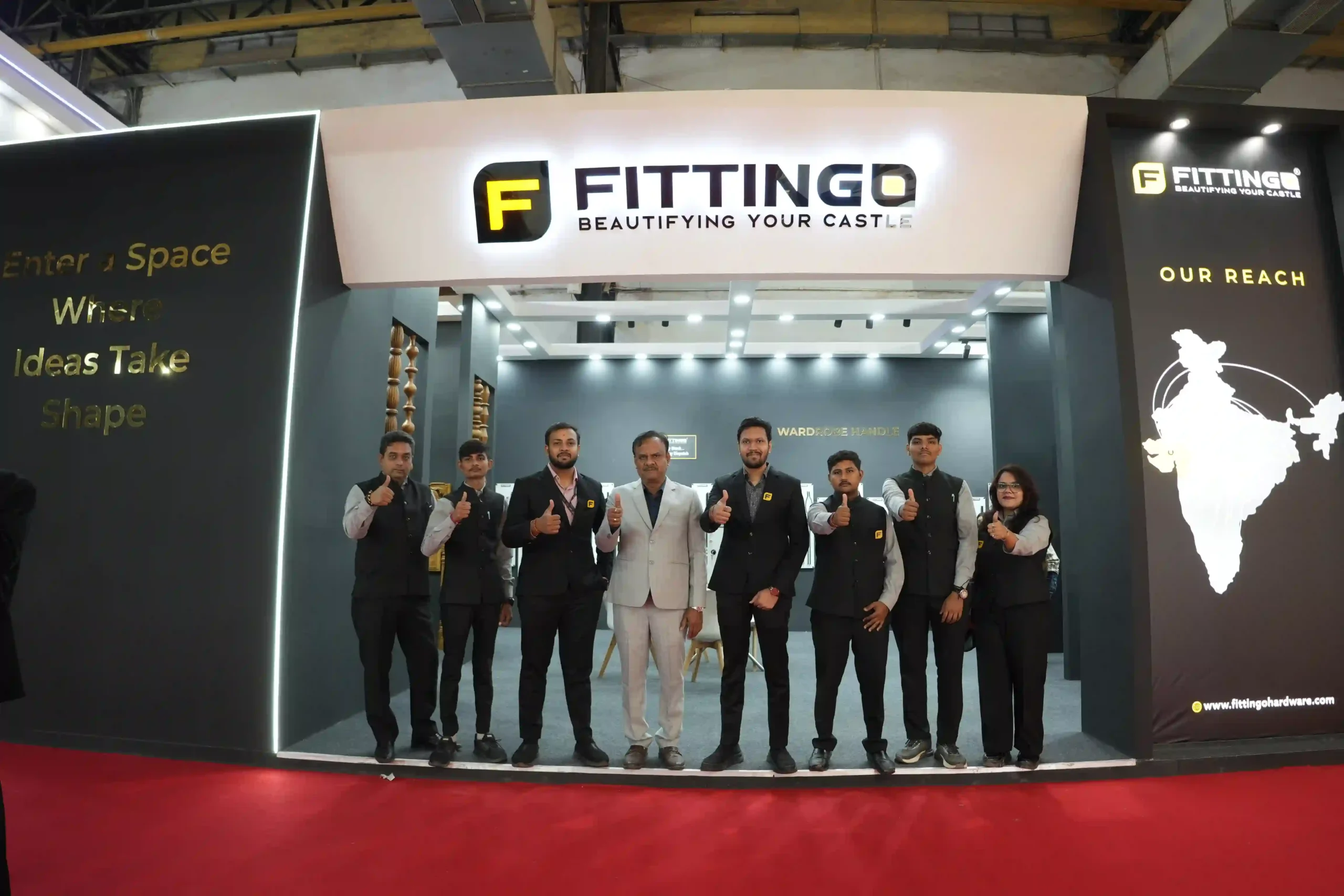The Fittingo team standing together in front of the stand