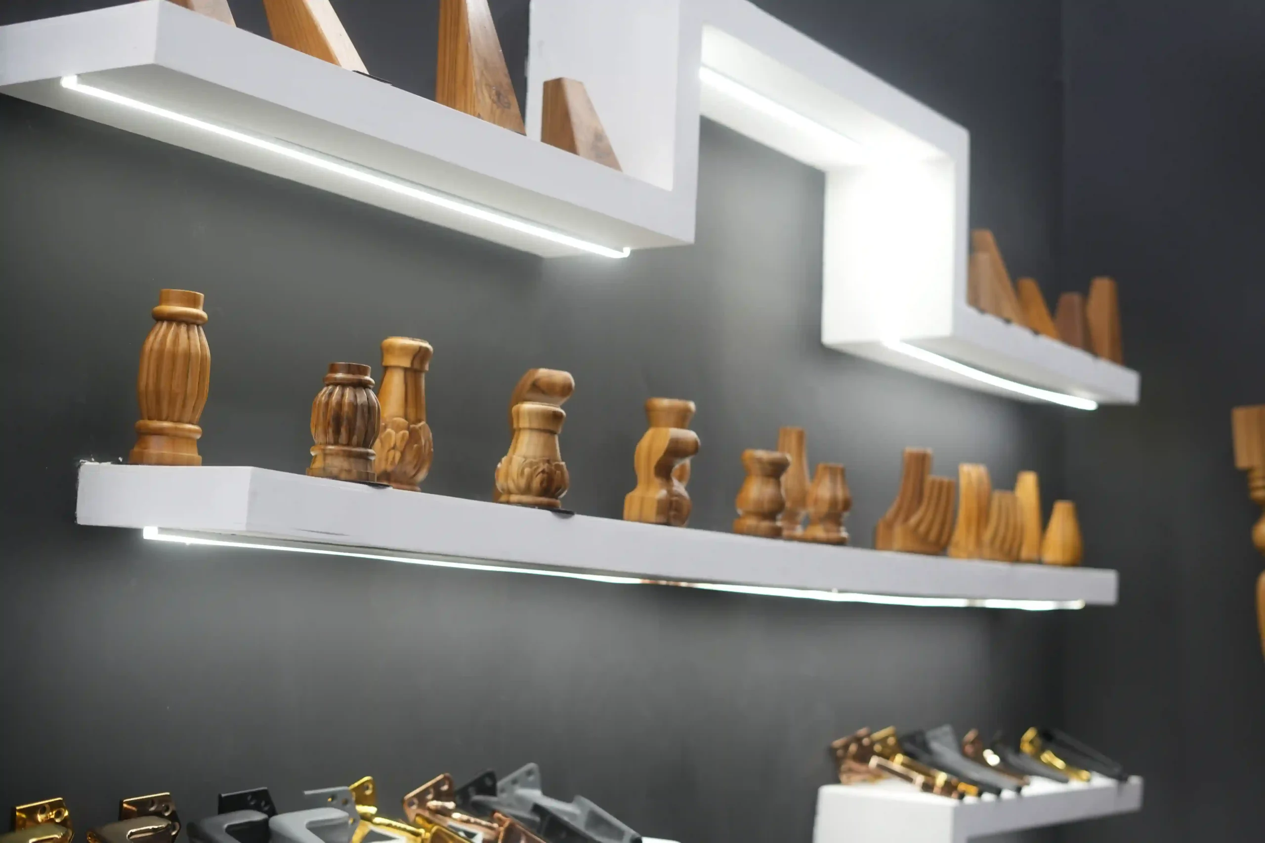 lit floating shelves of wooden leg profiles above a tray of metal brackets