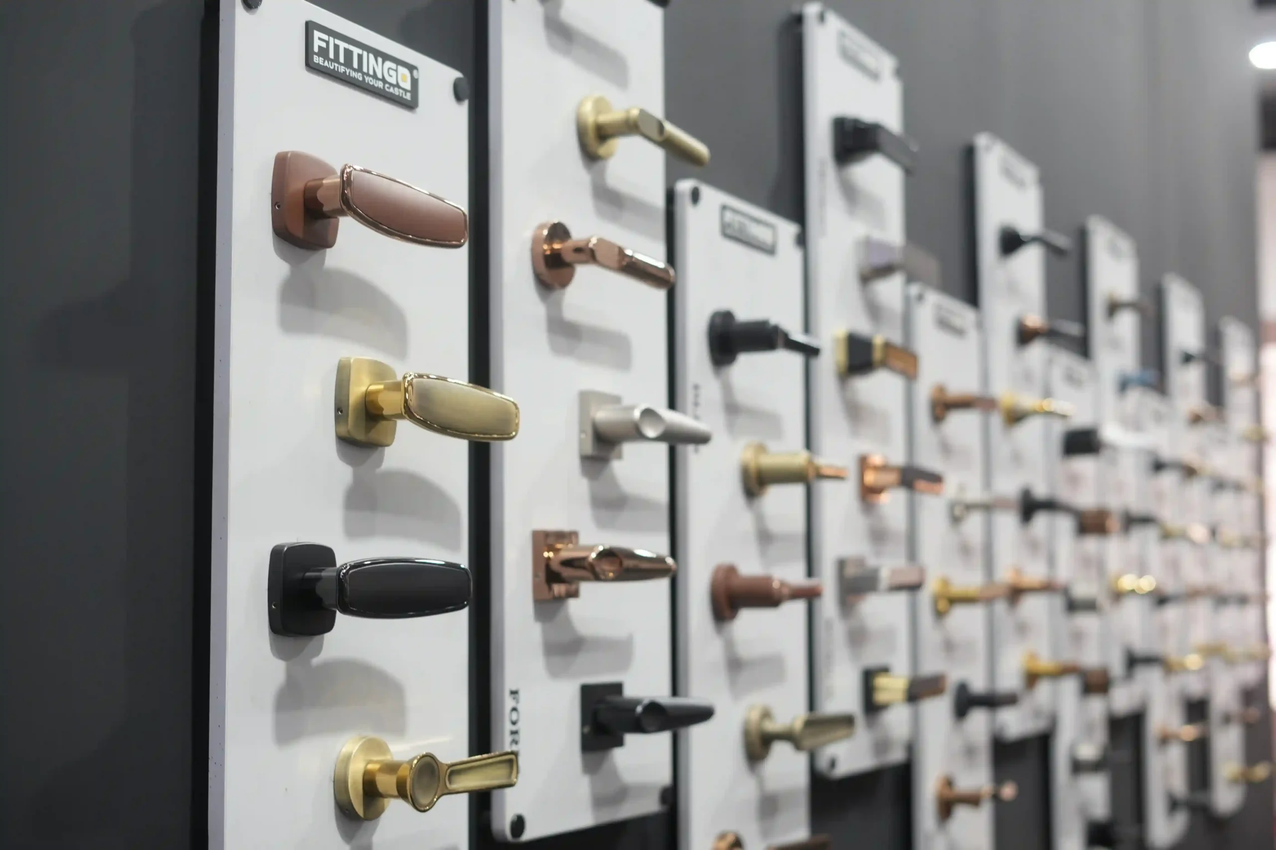 Wall of Fittingo lever handles in rose gold, satin brass, black and chrome PVD finishes
