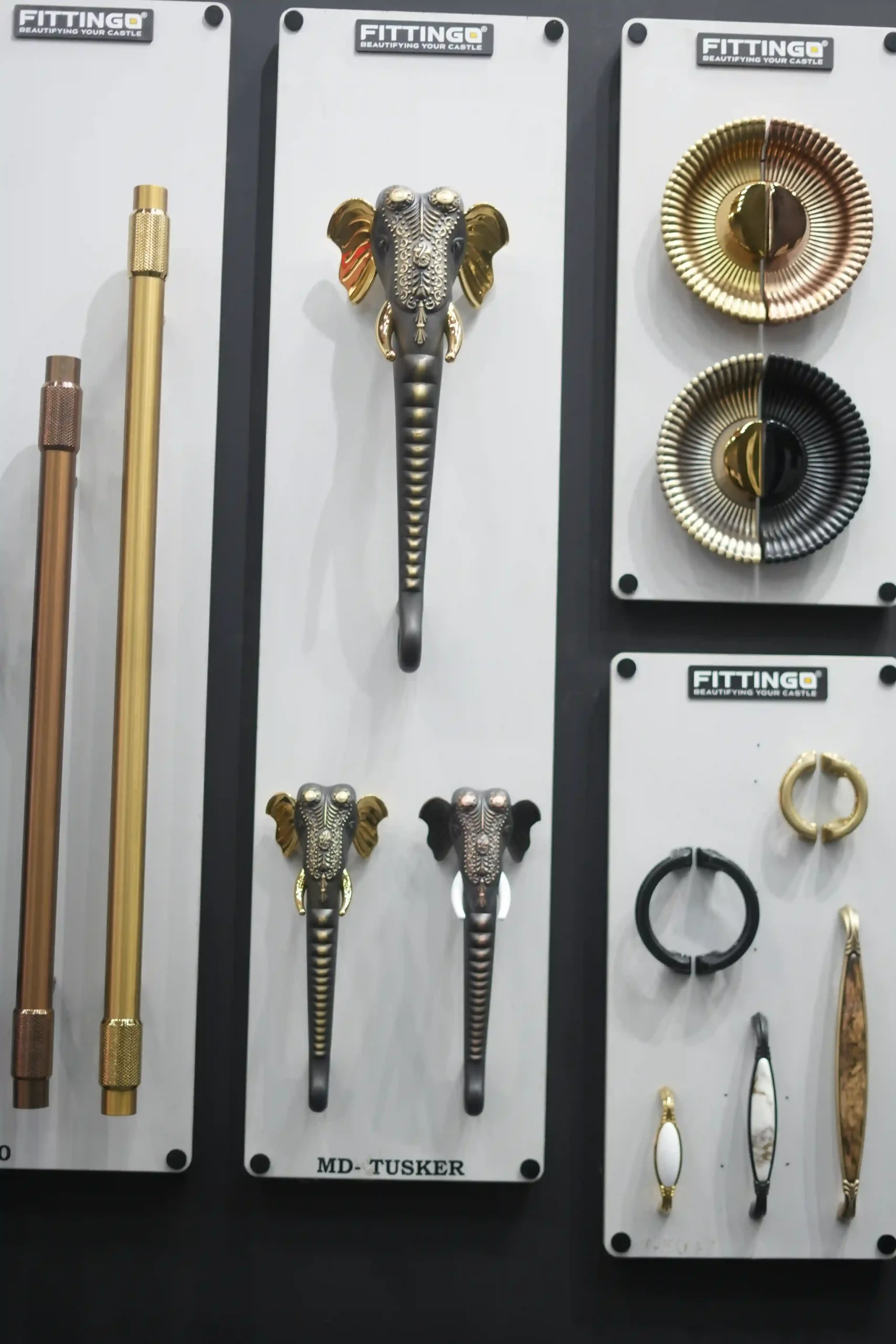 Knurled pull bars in copper and brass above ornate door handles and fluted rosette pulls