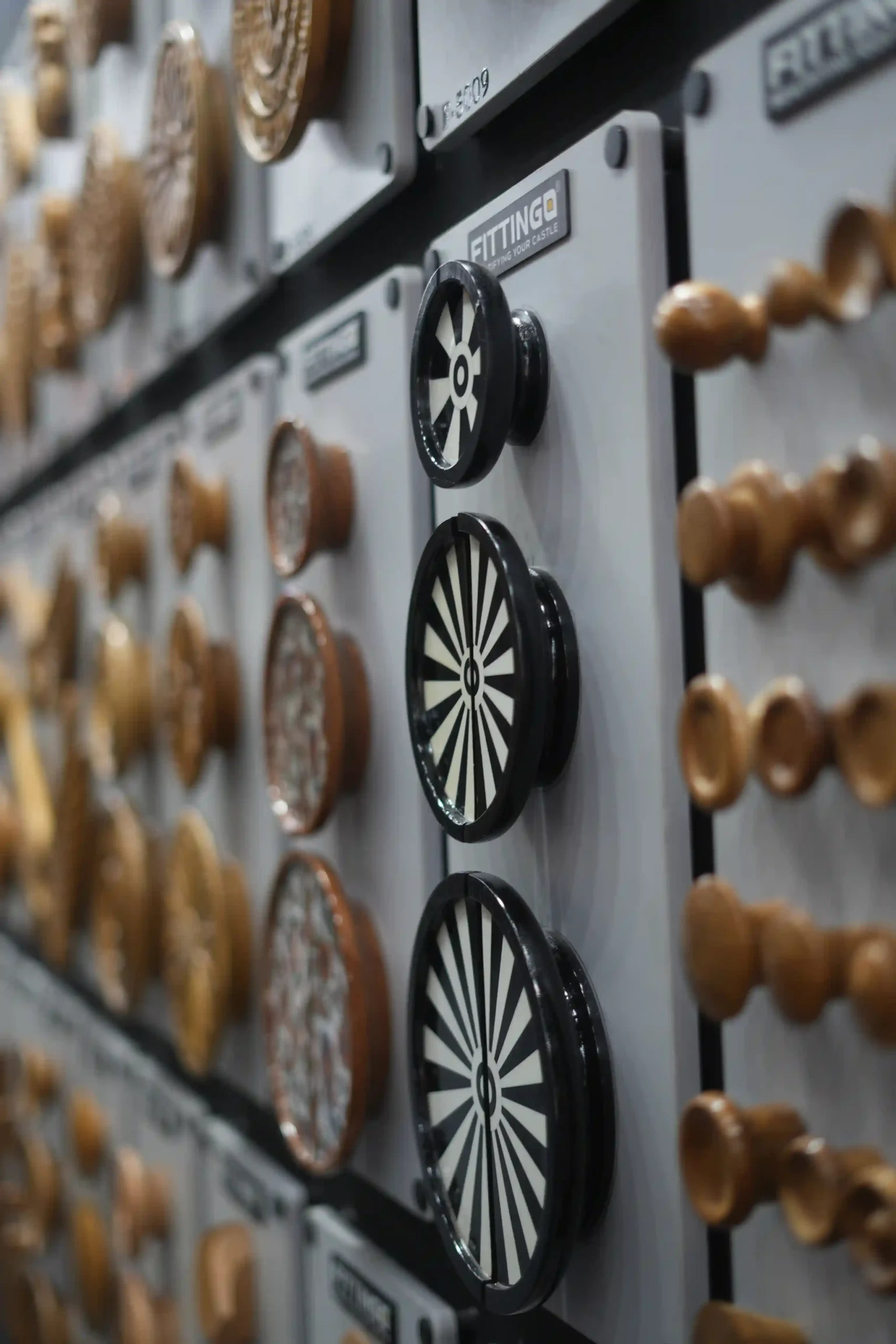 black and cream inlay knobs displayed among rows of turned wooden knobs