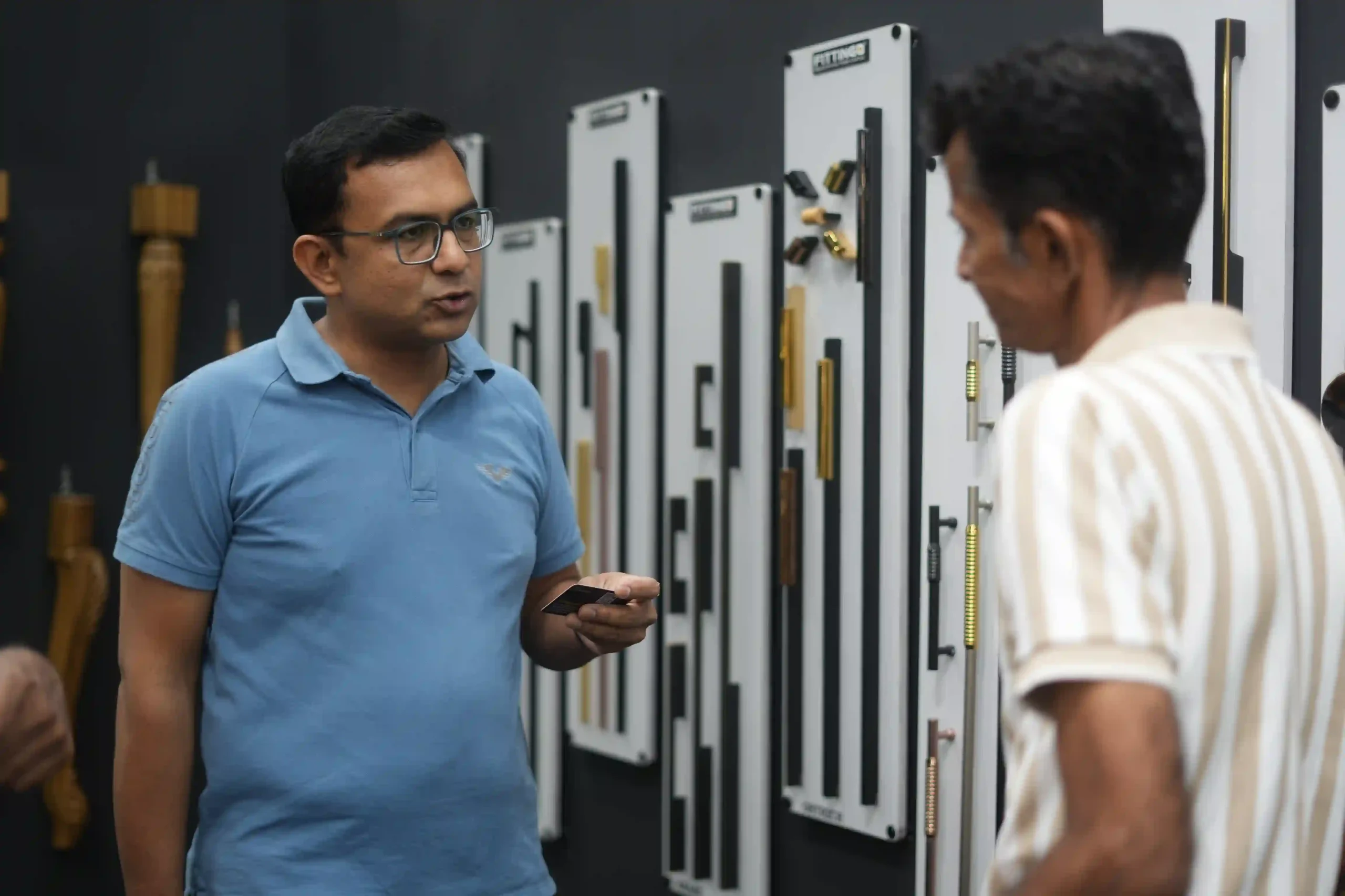 A Fittingo representative talking a visitor through the handle sample boards
