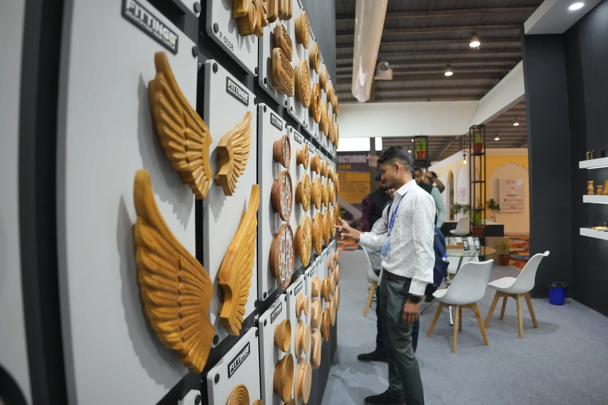 A visitor looking over the carved wooden onlay wall, including the winged and rosette profiles